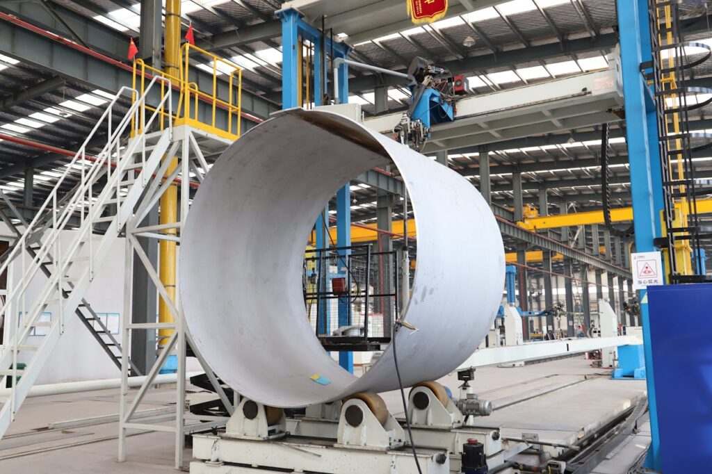 A spacious industrial factory scene showcasing steel pipe production with modern machinery.